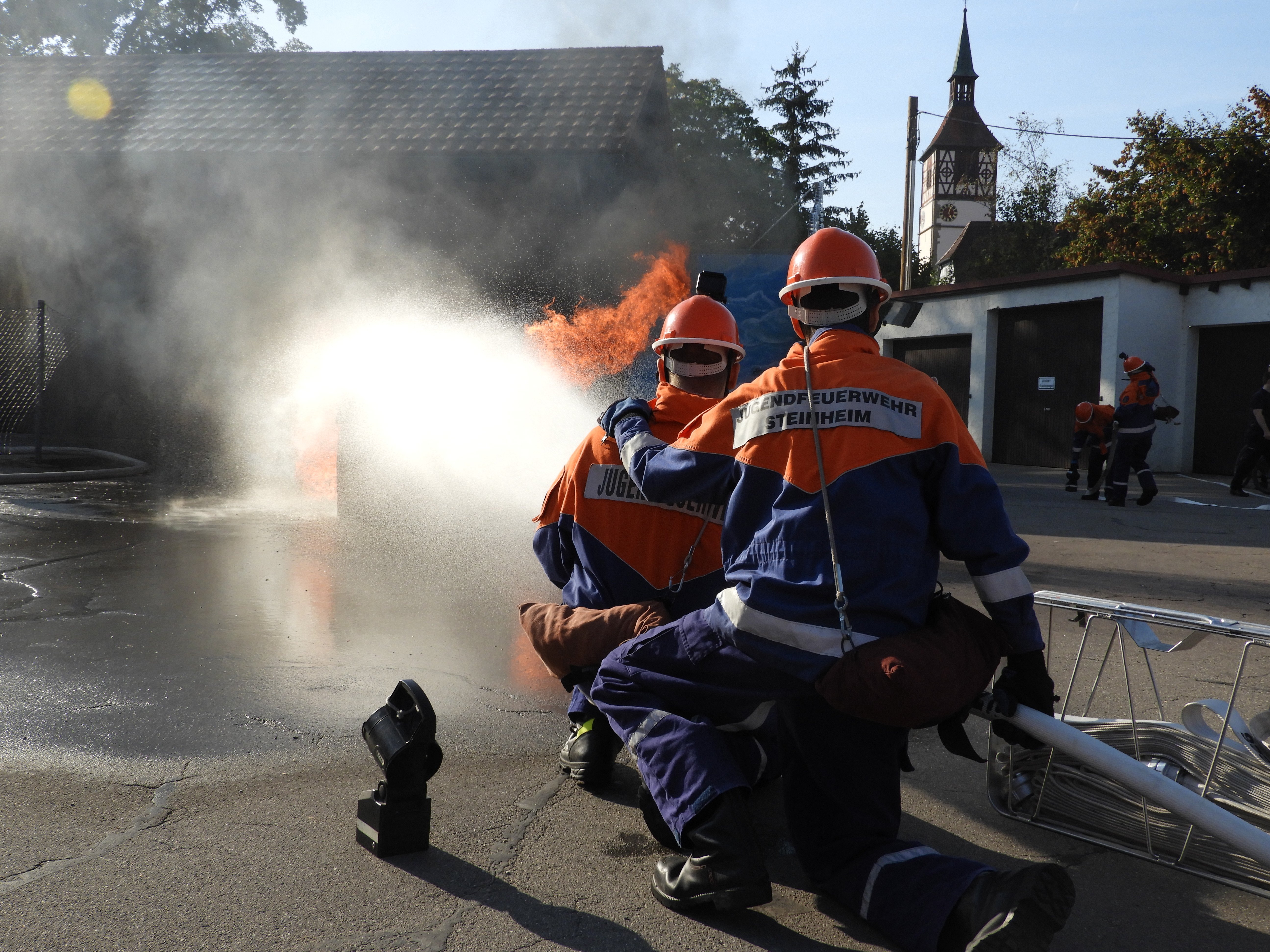 Zwei Mitglieder der Jugendfeuerwehr beim Löschen