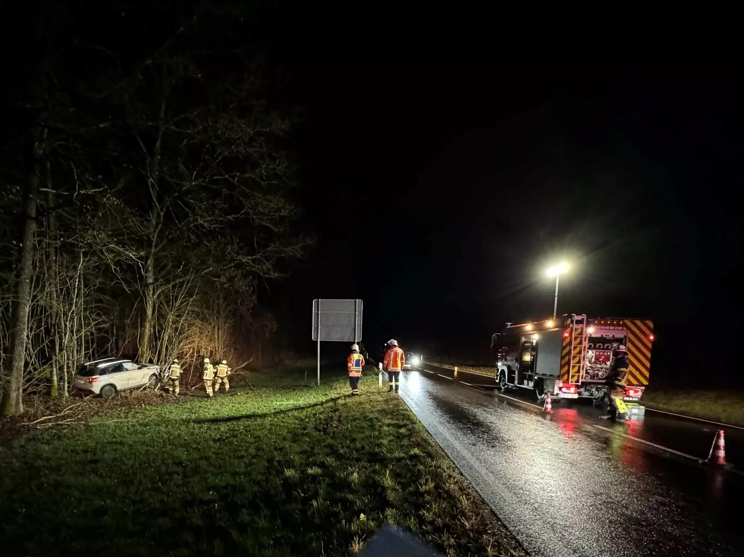 Ein verunfallter PKW sowie das Feuerwehrfahrzeug an der Einsatzstelle