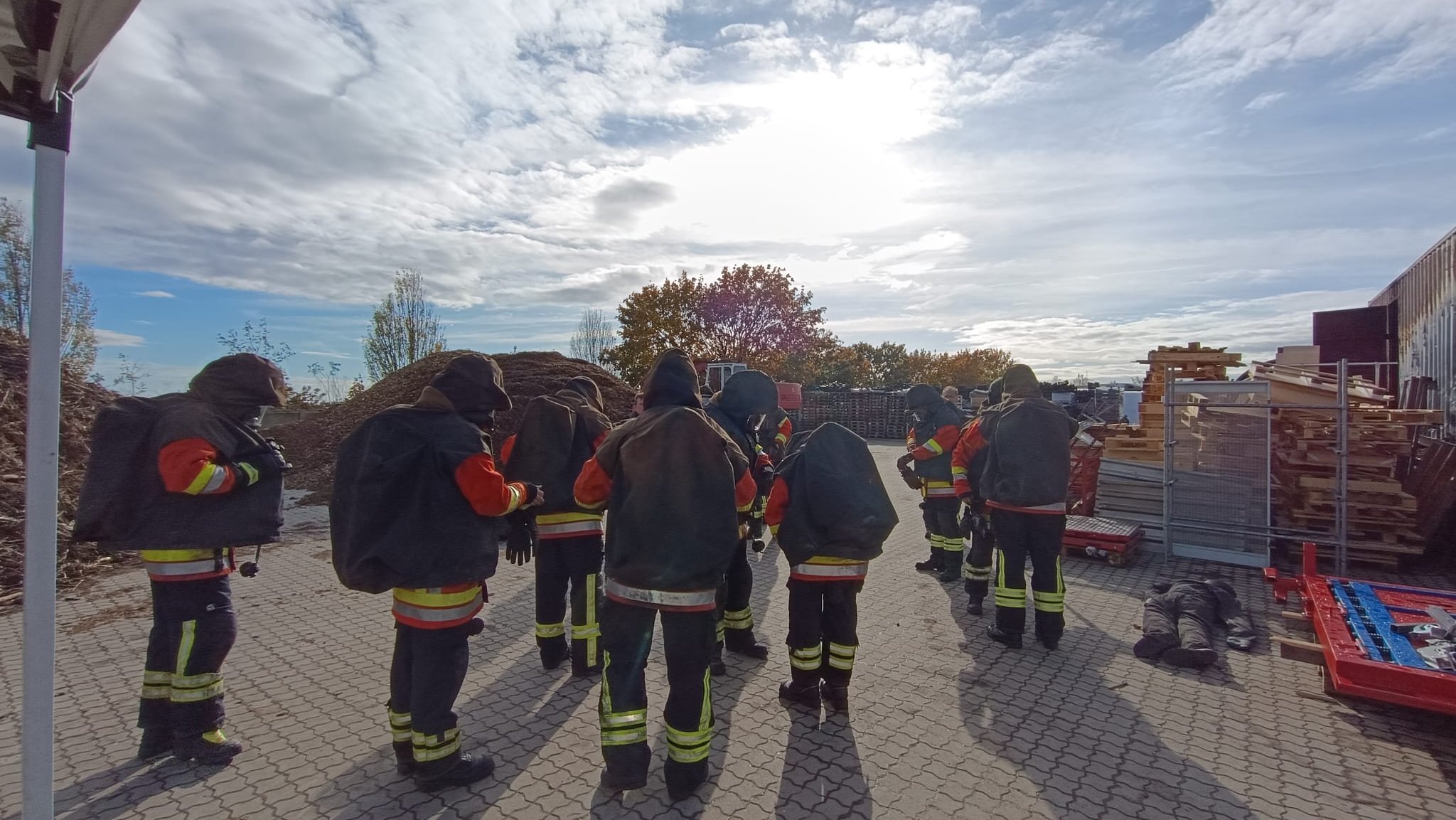 Eine Gruppe Feuerwehreinsatzkräfte steht in Schutzausrüstung bereit