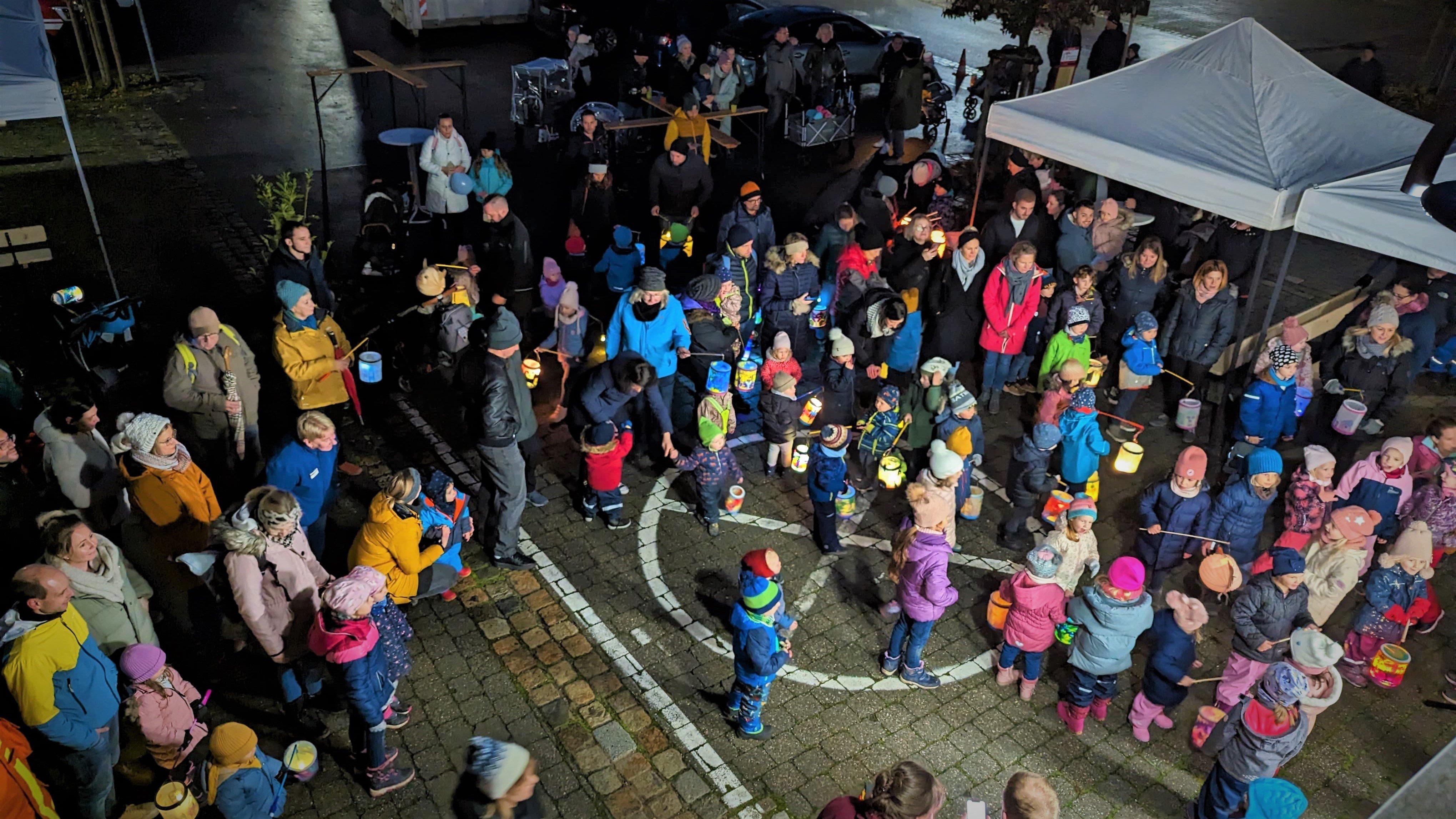 Kinder mit Laternen versammeln sich vor dem Feuerwehrhaus