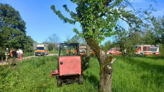 Feuerwehrfahrzeuge und ein Aufsitzrasenmäher an der Einsatzstelle